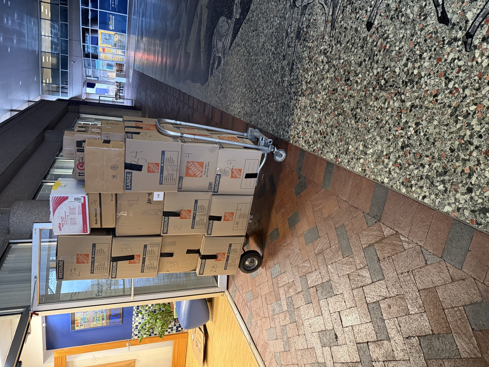 Stacked Home Depot moving boxes on a dolly, packed and ready to load by I&O Moving Smiths packing crew